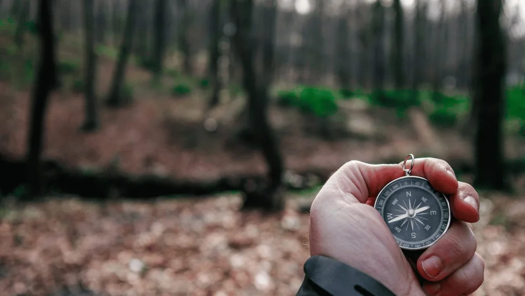 A hiker using a compass while hiking