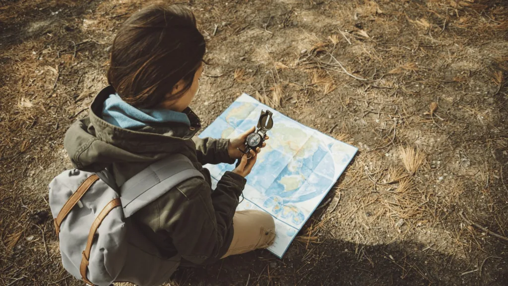 A hiker using a map and compass